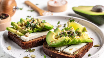 healthy toasts with avocado cheese and whole wheat rye bread on a plate