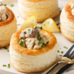 Delicious classic vol-au-vent stuffed with chicken, mushrooms in a creamy sauce close-up in a plate on the table