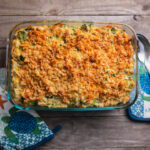 Broccoli Cheese Cracker Casserole served on a glass platter with oven mitten in the background