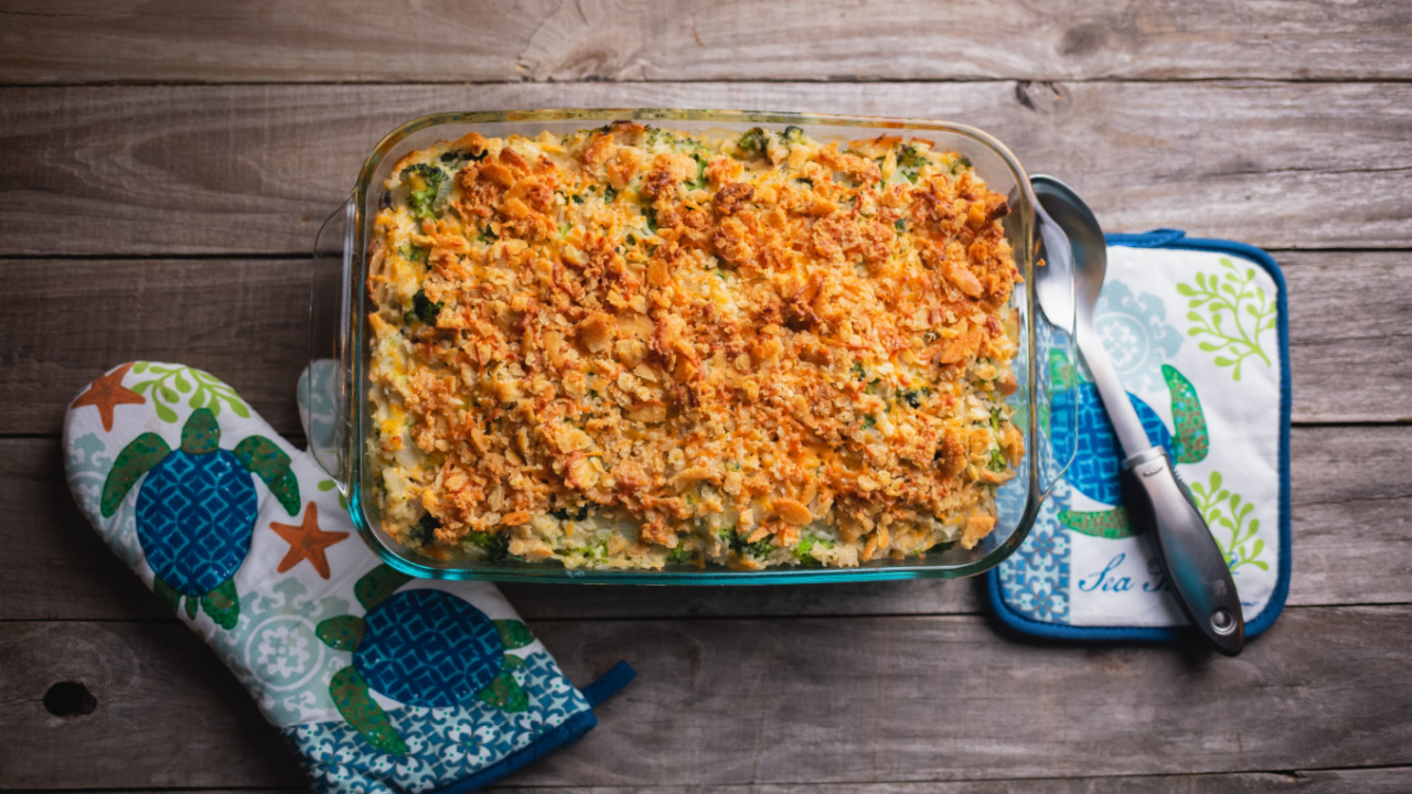 Broccoli Cheese Cracker Casserole served on a glass platter with oven mitten in the background