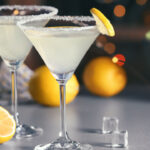 Glasses with tasty lemon drop martini cocktail on table