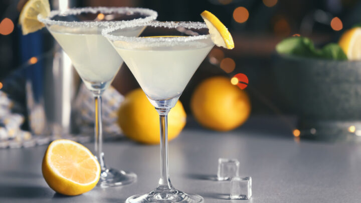 Glasses with tasty lemon drop martini cocktail on table