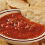 A bowl of restaurant style salsa with tortilla chips