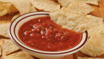 A bowl of restaurant style salsa with tortilla chips