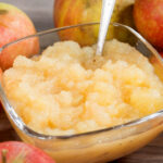 an applesauce with apples on a wooden table