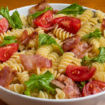 blt pasta salad consisting of rotini, bacon, lettuce and tomatoes.