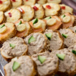 Bread spread with slices of roll with tuna and egg, cucumber slice and pepper. Party and event finger food.