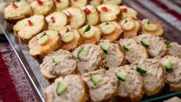 Bread spread with slices of roll with tuna and egg, cucumber slice and pepper. Party and event finger food.