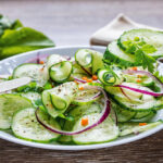 Healthy diet green salad with cucumbers in a white plate.