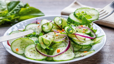 Healthy diet green salad with cucumbers in a white plate.