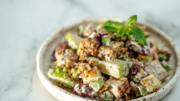 Waldorf salad with copy space. American fruit and nut salad with apples, celery, grapes, chicken meat, dressed mayonnaise.