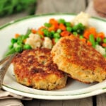 crab cake served with peas and carrots