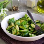 Fresh salad of cucumbers, green onions and fresh mint in an clay plate.