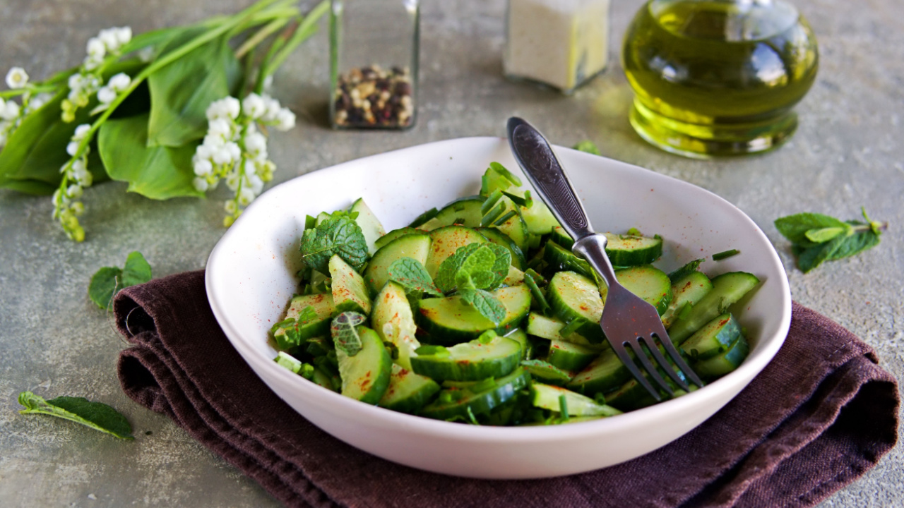 Fresh salad of cucumbers, green onions and fresh mint in an clay plate.