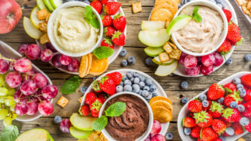 Homemade Sweet Hummus with strawberries, apple, crackers, grapes. Variations of different hummus dessert dips