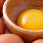 chicken egg yolk in a wooden bowl