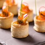 Delicious appetizers with graved salmon and golden caviar served in puff pastry towers.