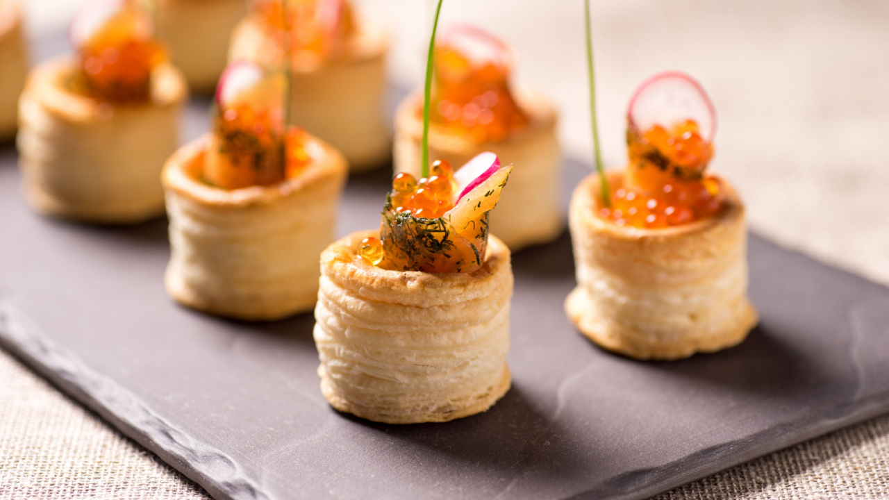 Delicious appetizers with graved salmon and golden caviar served in puff pastry towers.