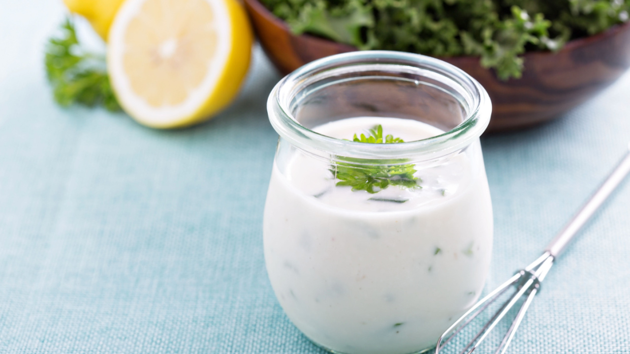 Homemade ranch dressing in a small jar with herbs