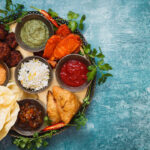 Vegetarian Thali. Indian appetizers and snacks: pakora, samosas and bhaji served with chutneys and other dipping sauces.