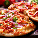 delicious indian chicken pizza served on a wooden board