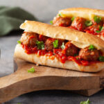 meatball sub sandwich with cheese and marinara tomato sauce.
