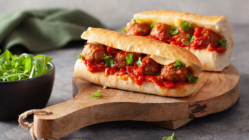 meatball sub sandwich with cheese and marinara tomato sauce.