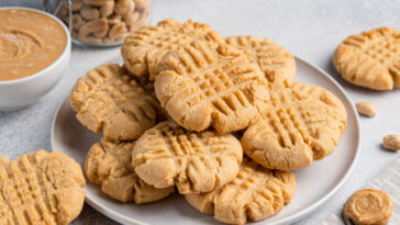 Peanut butter cookies stacked on ceramic plate.
