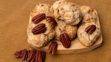 crispy pecan sandies cookies on a brown paper towel. cookies with buttery, and nutty goodness.