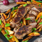 Roast Pork tenderloin with vegetables and potatoes.