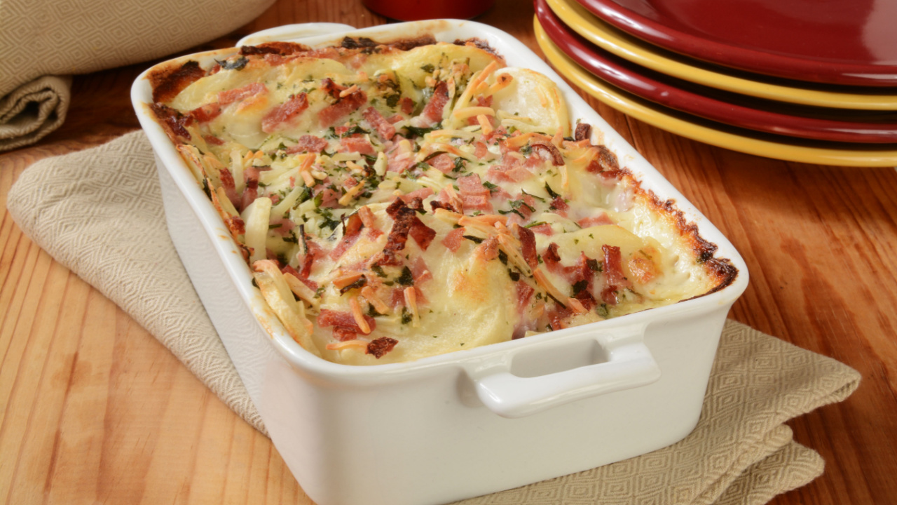 Scalloped potatoes in cheese sauce with ham in a casserole dish