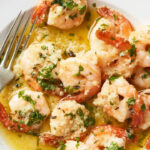 Shrimp Scampi with fork served on a white plate