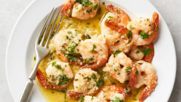 Shrimp Scampi with fork served on a white plate