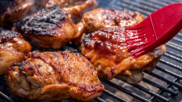 BBQ chicken thigh on the flaming grill