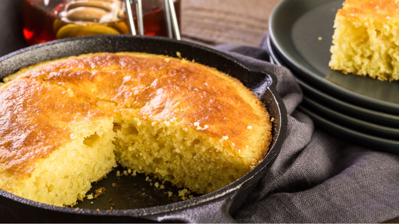 Slice of sweet cornbread with honey on the plate.