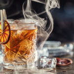 Smoked old fashioned rum cocktail with cubes of ice.