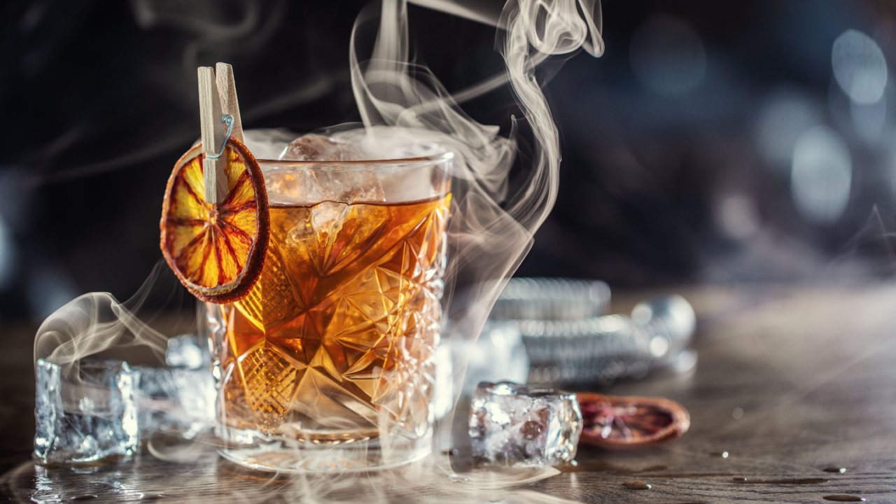 Smoked old fashioned rum cocktail with cubes of ice.