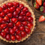 delicious strawberry tart on wooden background, top view, copy space
