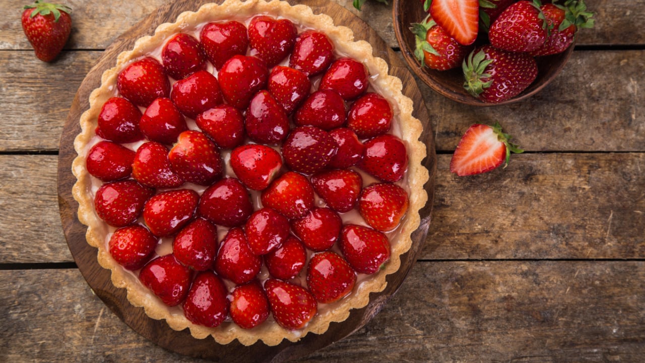 delicious strawberry tart on wooden background, top view, copy space