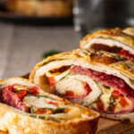 Traditional Italian Stromboli stuffed with cheese, salami, red pepper and spinach.