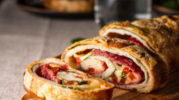 Traditional Italian Stromboli stuffed with cheese, salami, red pepper and spinach.
