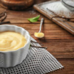 Vanilla pudding in ceramic bowl on wooden table