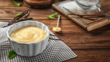 Vanilla pudding in ceramic bowl on wooden table