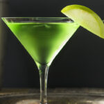 Homemade Green Alcoholic Appletini Cocktail with Apple Garnish