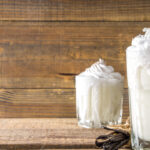 Vanilla bean milkshake. Glass with cold Vanilla milkshake with Vanilla beans.