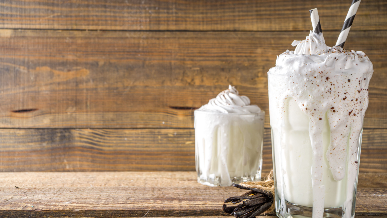 Vanilla bean milkshake. Glass with cold Vanilla milkshake with Vanilla beans.
