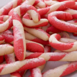A plate of homemade candy cane cookies sprinkled with granulated sugar.