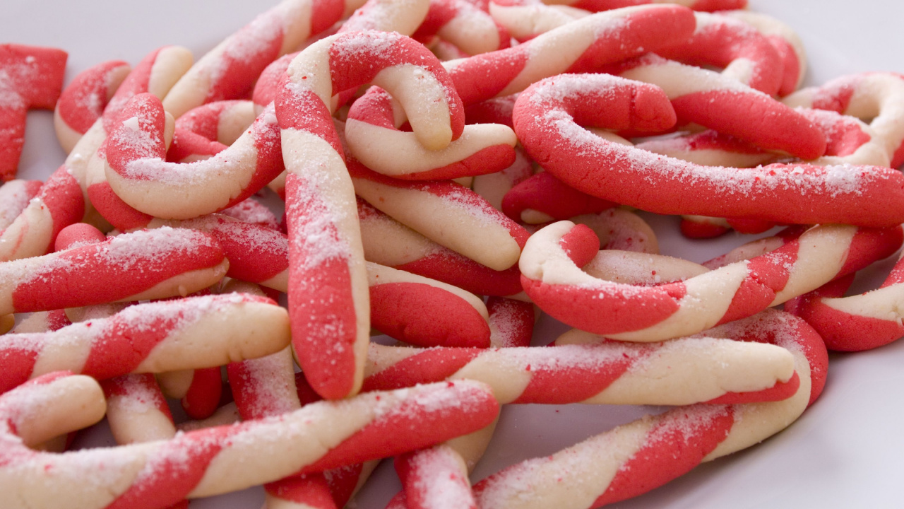 A plate of homemade candy cane cookies sprinkled with granulated sugar.