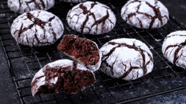 Chocolate crinkle cookies on a dark background.