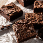 Homemade pieces of dark chocolate brownies on rustic wooden table